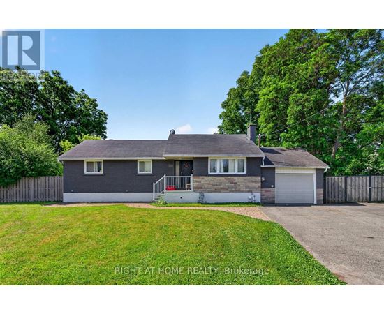 A house with a grey roof and a white garage door is for sale.
