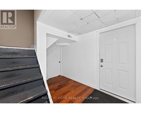 A room with a white door and a staircase.