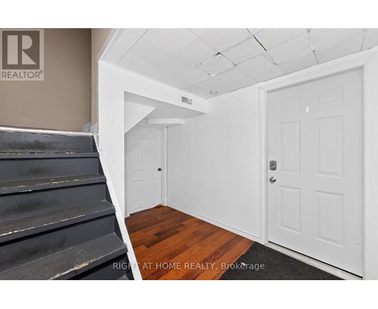 A room with a white door and a staircase.