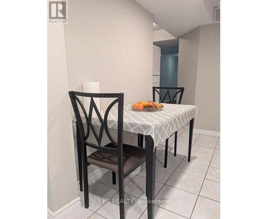A dining table with a white tablecloth and a chair in a room.
