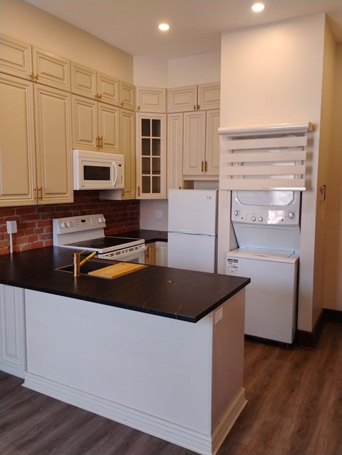 A kitchen with white appliances and wooden cabinets.