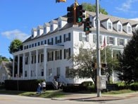 A white building with a green traffic light in front of it.