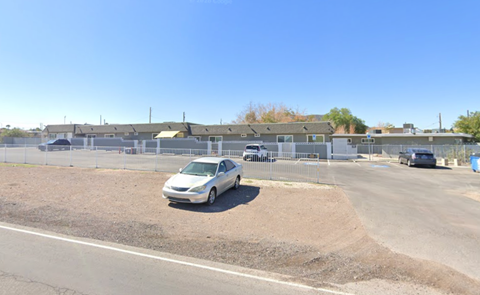 A white car is parked on the side of a road.