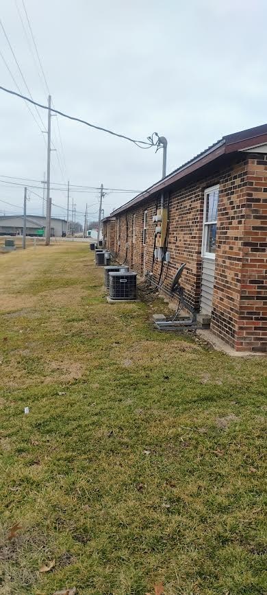 A grassy area with a building and power lines in the background.