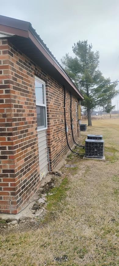 A brick house with a window and a tree in the background.