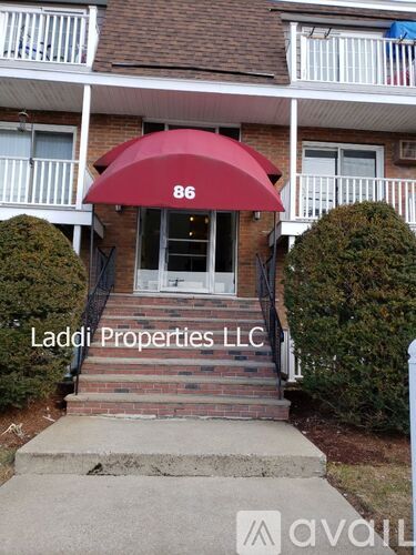 A red awning with the number 86 on it is above the door of a building.
