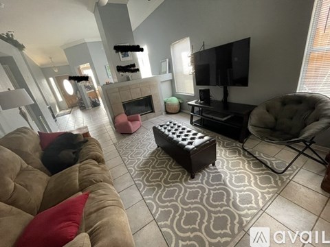 A cat is sleeping on a brown couch in a living room.
