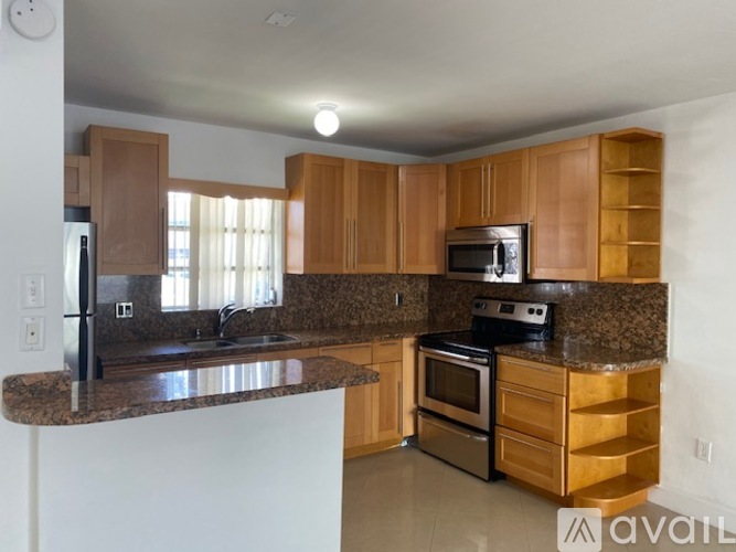 A kitchen with wooden cabinets and granite countertops.