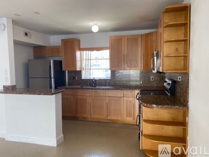 A kitchen with wooden cabinets and granite countertops.