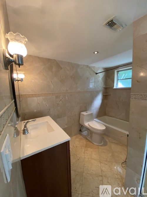 A bathroom with a toilet, sink, and mirror.
