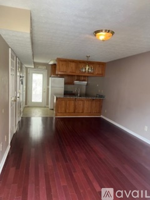 A kitchen with wooden cabinets and a refrigerator.