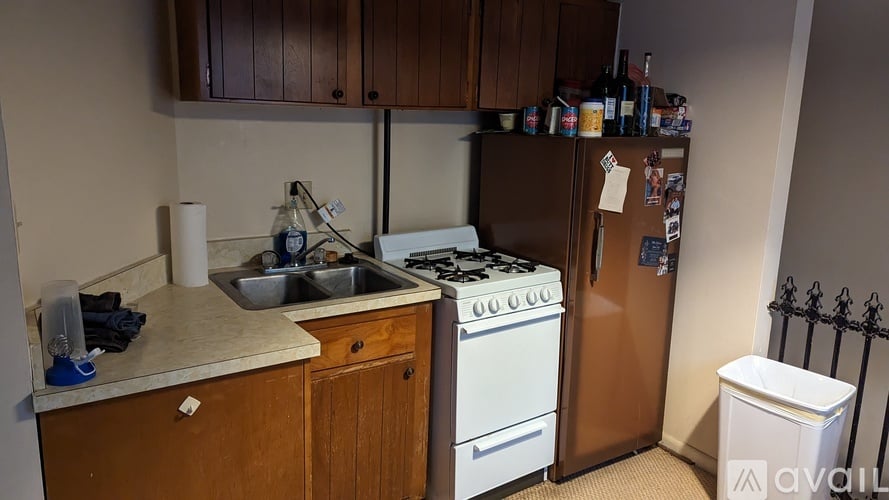 A kitchen with a white stove and a refrigerator covered in magnets.