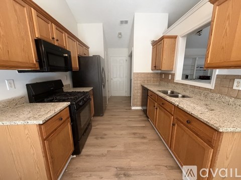 A kitchen with wooden cabinets and granite countertops.