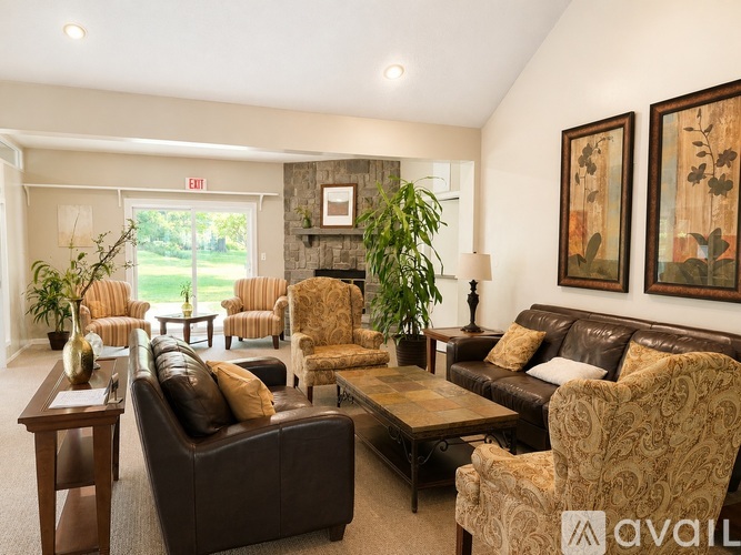 A living room with a brown couch and chairs.