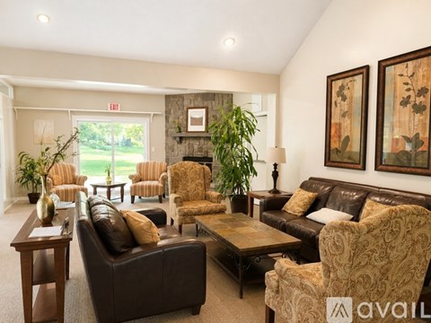 A living room with a brown couch and chairs.