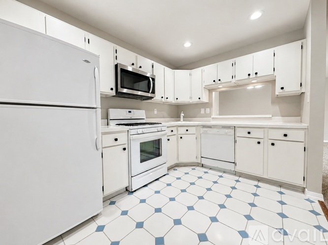 A kitchen with white appliances and cabinets.