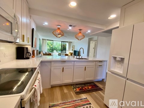 A kitchen with white cabinets and a black stove top.