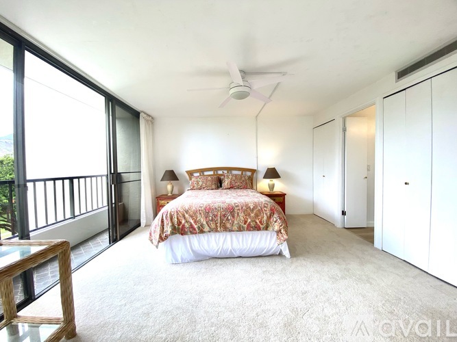 A bedroom with a large bed and a ceiling fan.
