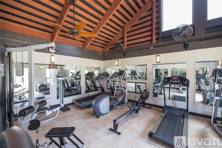A gym with a variety of equipment including treadmills, weights, and exercise machines.