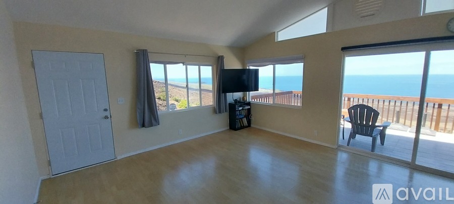 A living room with a view of the ocean.