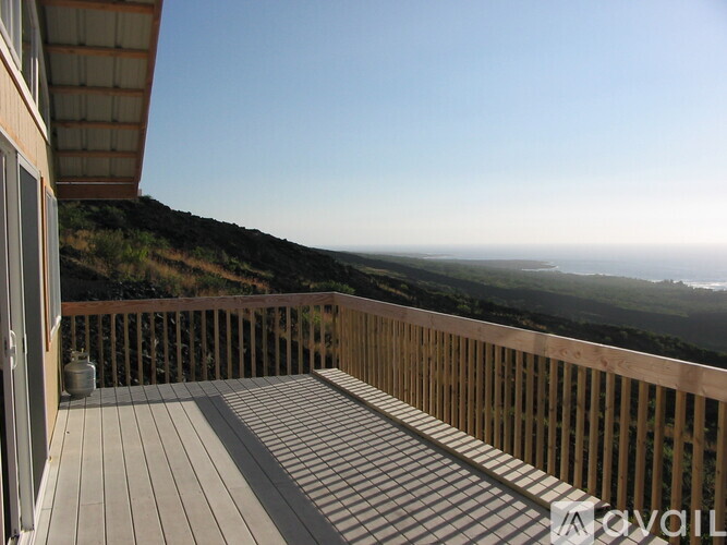 A wooden deck overlooks a grassy hillside.
