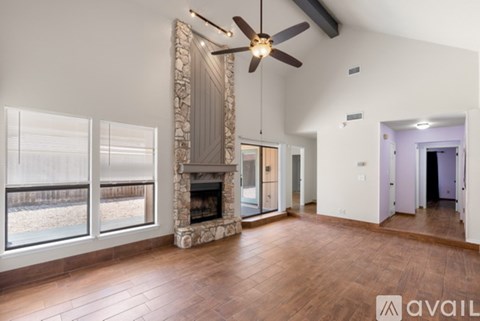 A spacious room with a fireplace and a ceiling fan.