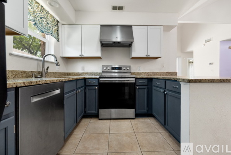A kitchen with dark blue cabinets and a stainless steel refrigerator.