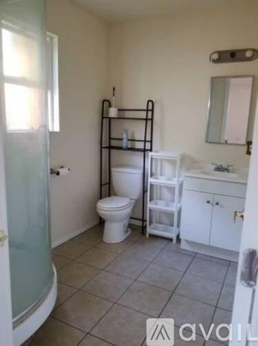 A bathroom with a toilet, sink, and a towel rack.