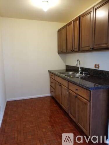 A kitchen with wooden cabinets and a black countertop.