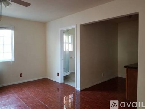 A room with a ceiling fan and a door leading to another room.