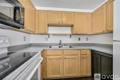 A kitchen with wooden cabinets and a black countertop.