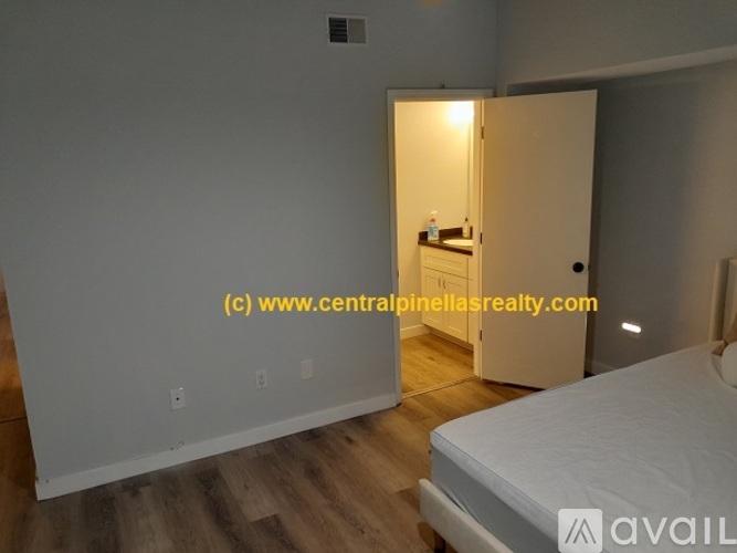 A bedroom with a bed, dresser, and mirror in a small space.