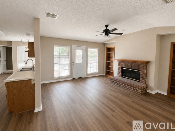 A living room with a fireplace and a ceiling fan.