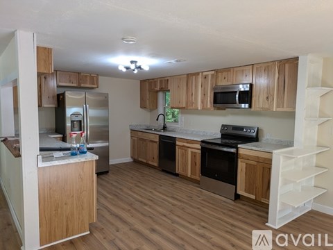A kitchen with wooden cabinets and a refrigerator.