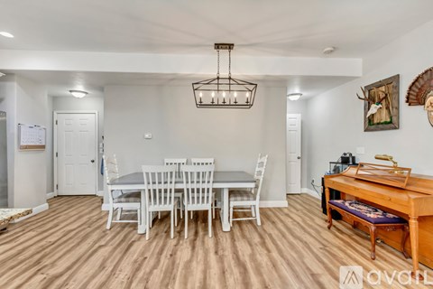 A dining room with a white table and chairs.