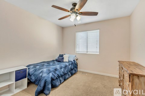 A bedroom with a bed, dresser, and window with blinds.