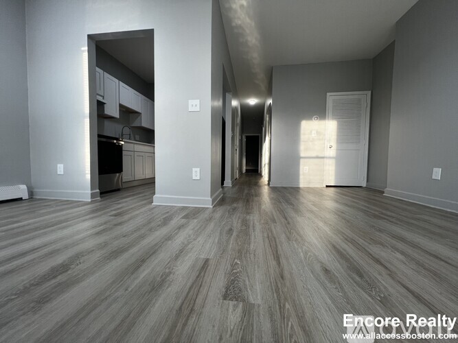 A spacious room with wood flooring and a white ceiling.