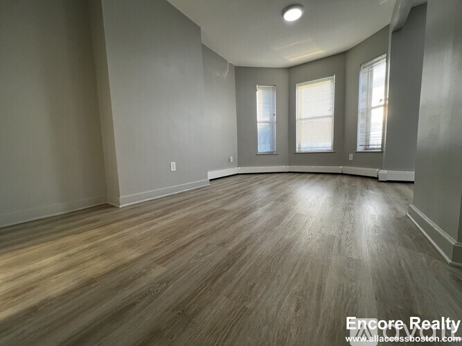 A room with wooden flooring and a vaulted ceiling.