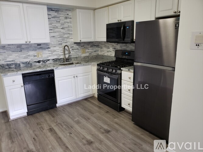 A kitchen with a black oven and a stainless steel refrigerator.