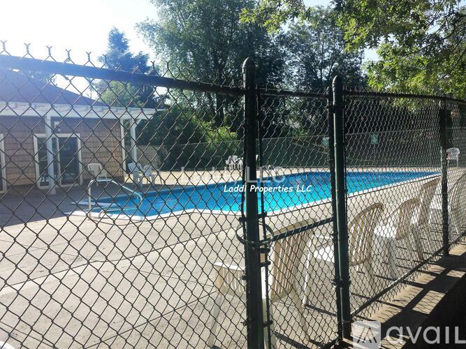 A pool surrounded by a black fence with the words "Ladd Properties LLC" written on it.