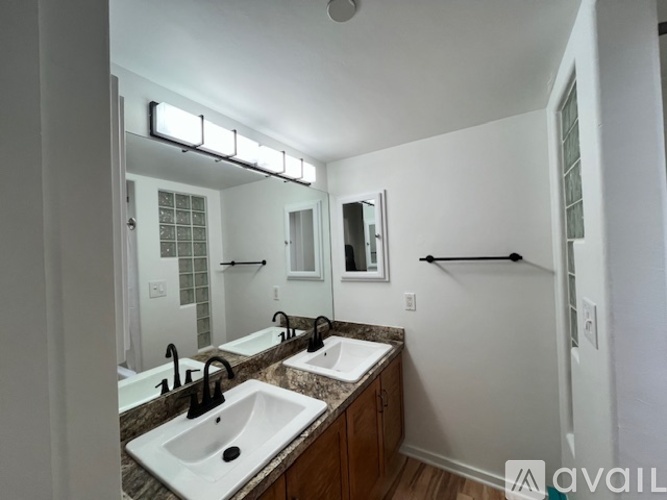 A bathroom with two sinks and a large mirror.