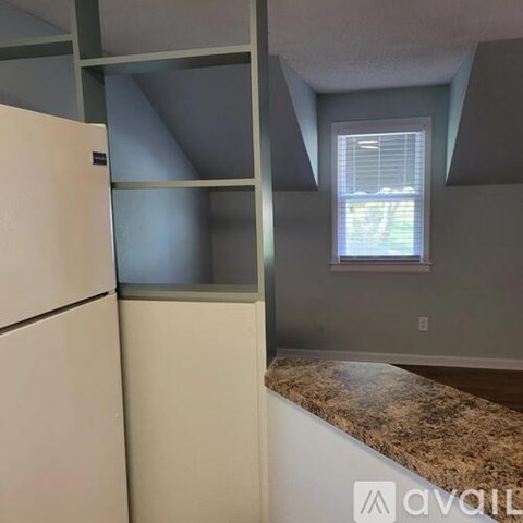 A kitchen with a granite counter and a window.