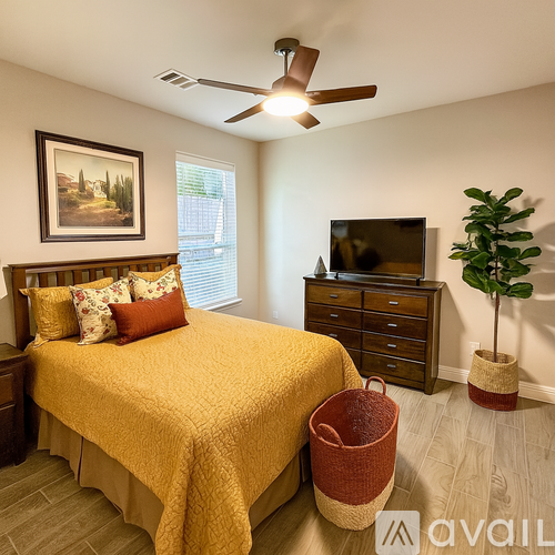 A bedroom with a bed, dresser, and ceiling fan.