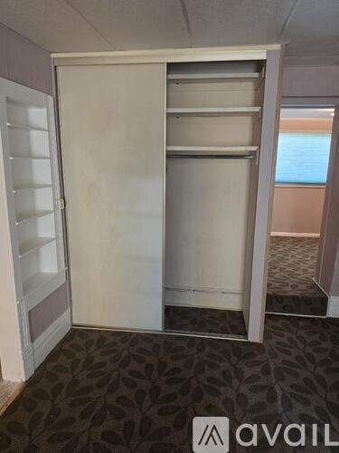 A large white closet with a sliding door is open.