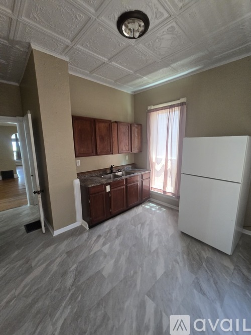 A kitchen with a white refrigerator and wooden cabinets.