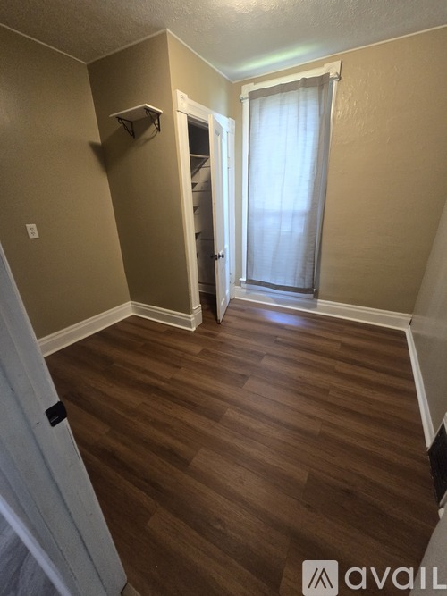 A room with wooden flooring and a white door.