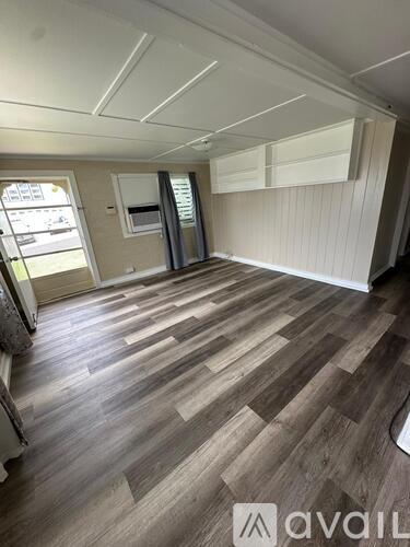 A room with wooden flooring and a window.