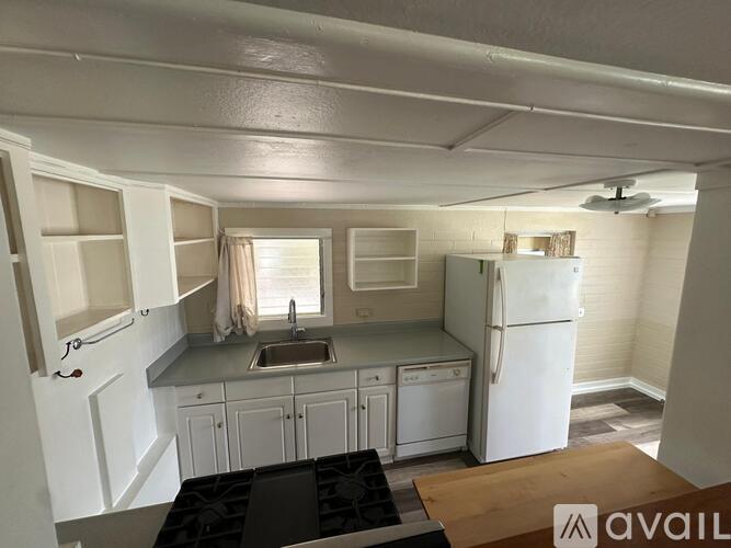 A kitchen with white cabinets and a white fridge.