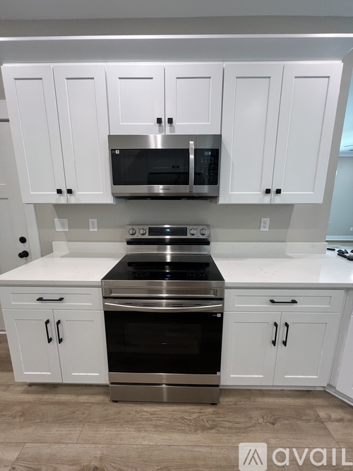 A kitchen with white cabinets and a stainless steel oven.