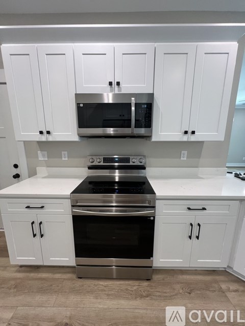 A kitchen with white cabinets and a stainless steel oven.